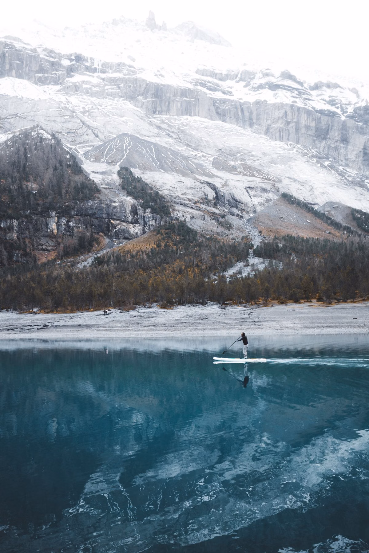 A paddler on calm lake water